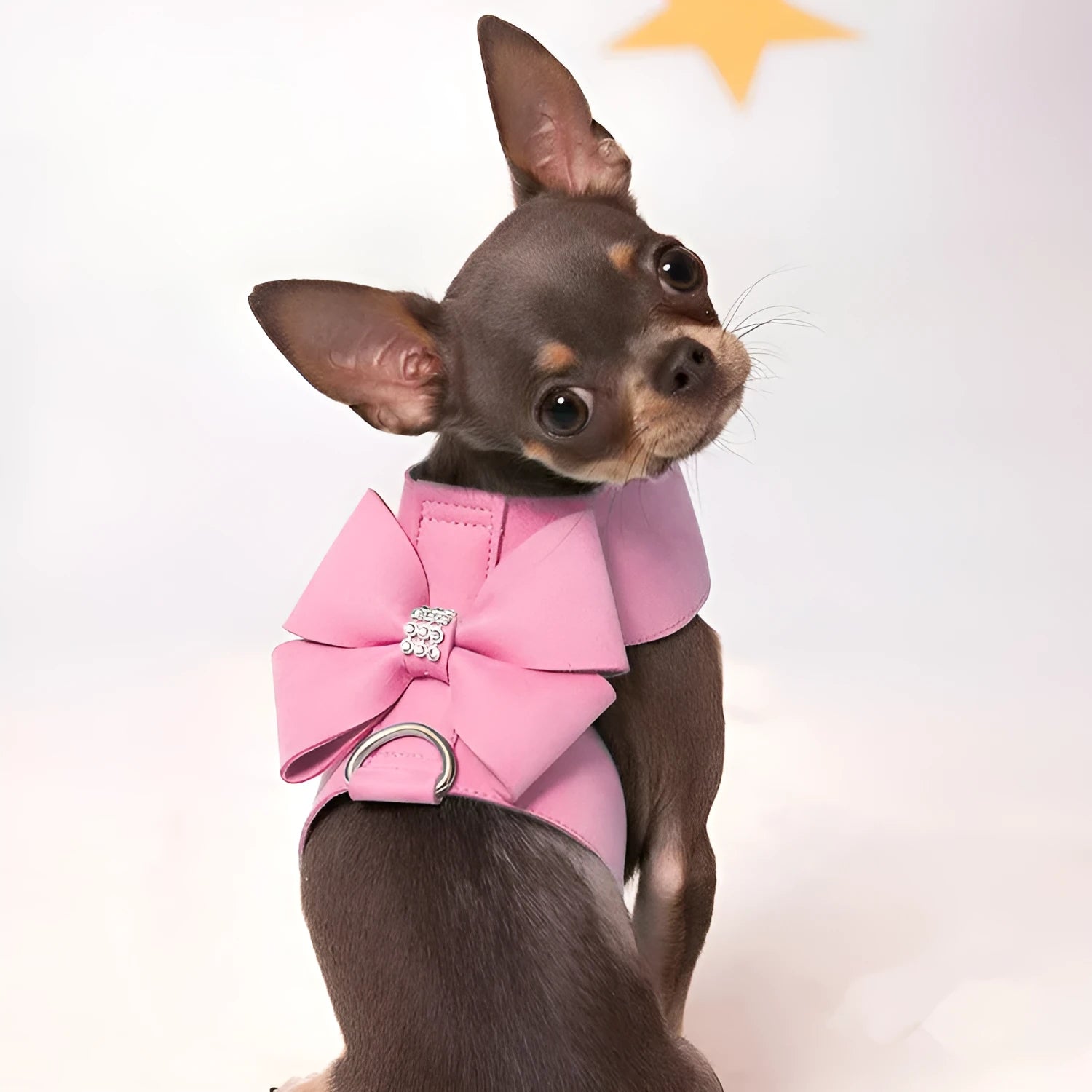A pink microfiber dog chest strap with a decorative bow, sized for a small puppy.