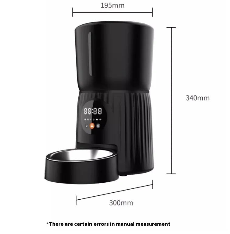 Black automatic pet feeder with digital display and food hopper on a wooden floor.