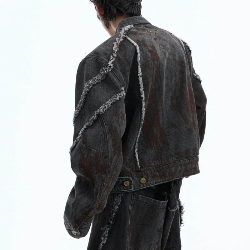 Distressed black gradient denim coat with padded shoulders and matching trousers laid flat