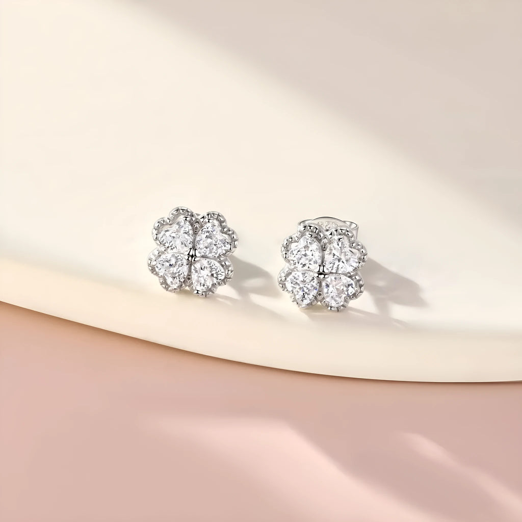 A pair of 925 silver earrings with a heart and four-leaf clover design, set with zircon stones in a white gold colour finish.