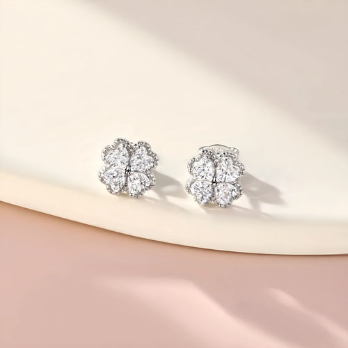 A pair of 925 silver earrings with a heart and four-leaf clover design, set with zircon stones in a white gold colour finish.