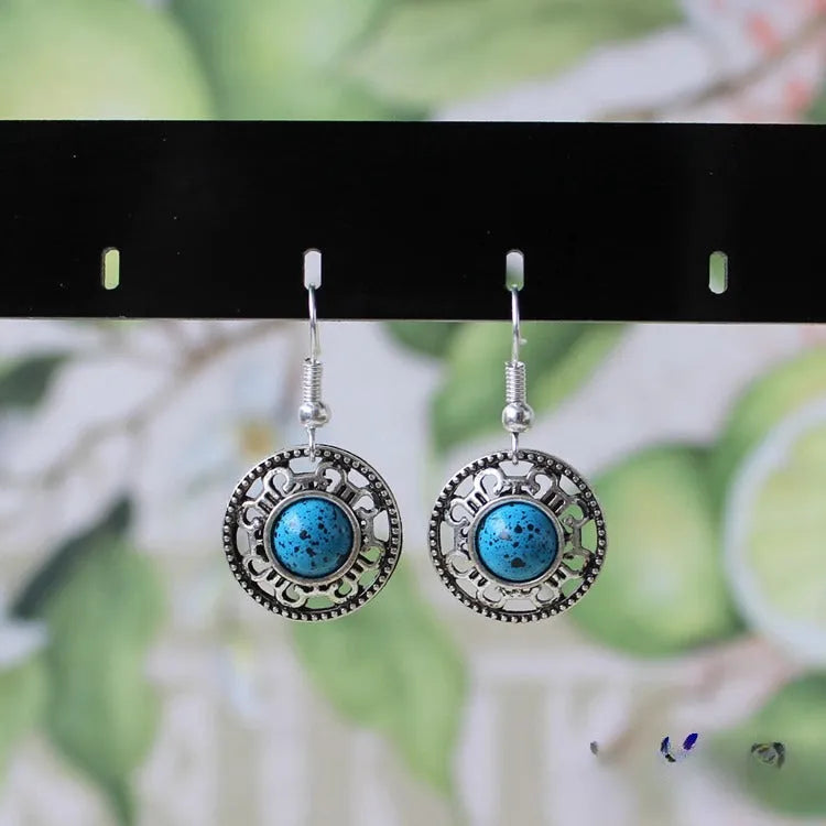 Handmade Miao silver and turquoise geometric flower disk earrings with totem patterns.