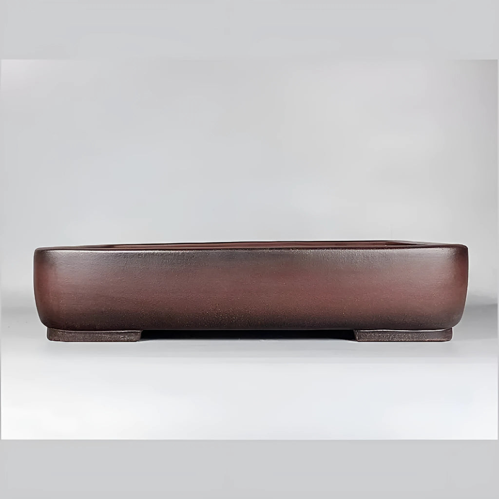 Handmade large rectangular purple clay flower pot for floor plants on a table.
