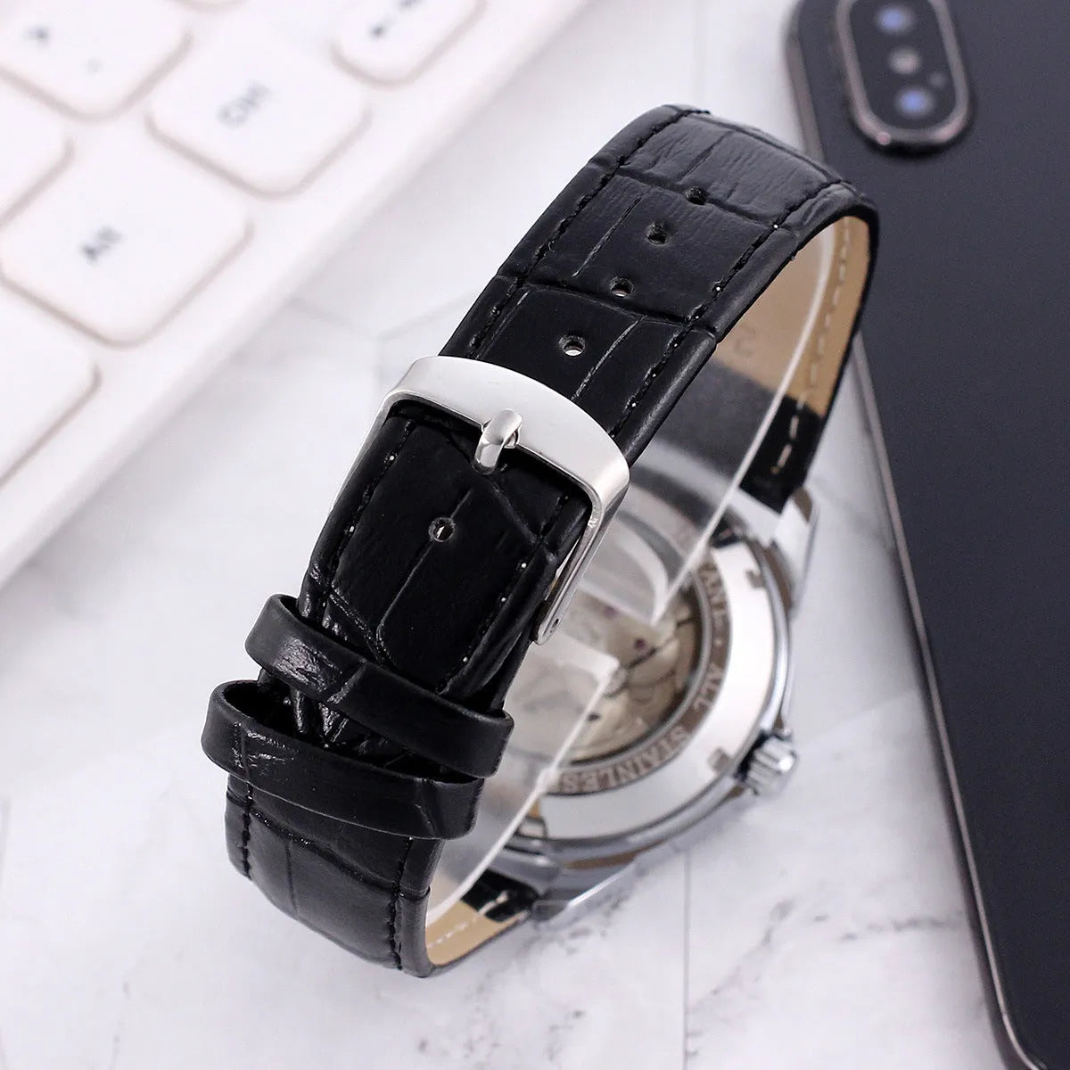 Men's transparent skeleton quartz watch with genuine leather strap on wrist, 37mm dial, alloy case, and stainless steel buckle