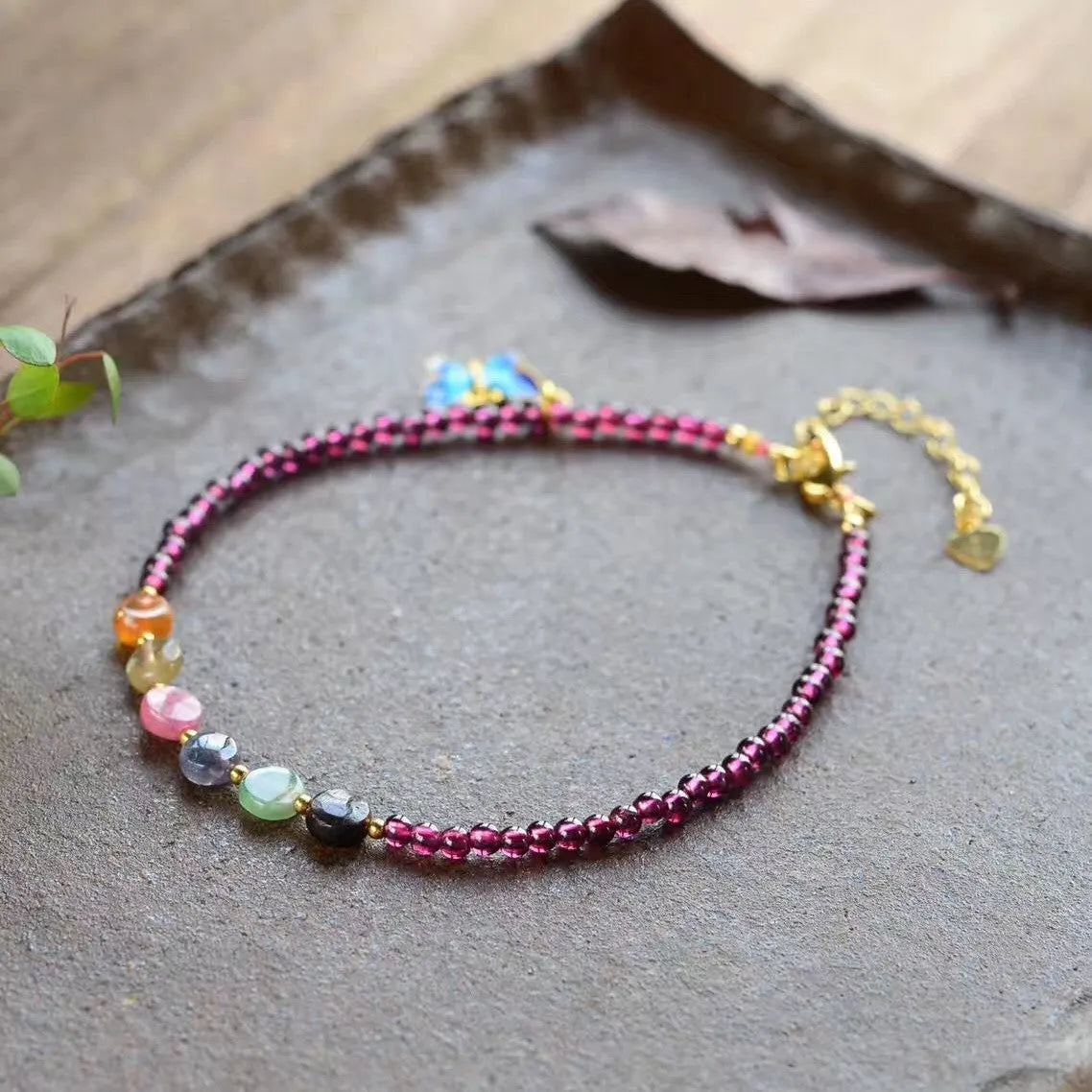 Purple garnet geometric anklet for women on an ankle.
