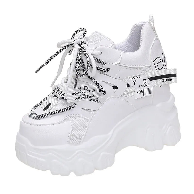 White women's low-top platform sports shoes with a cross-strap over a shallow-cut collar and a thick rubber sole.