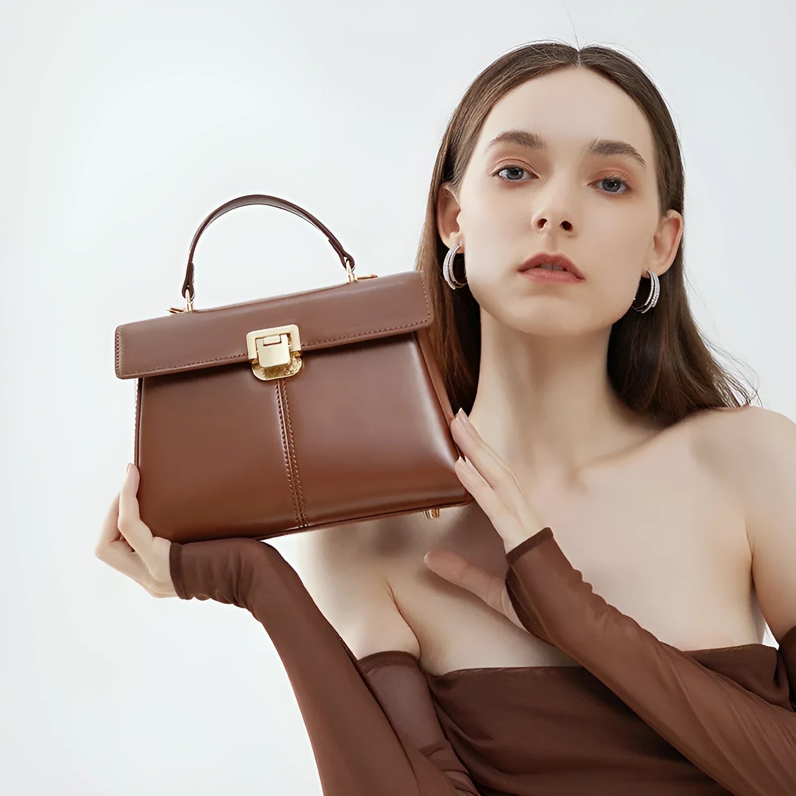 Women's black genuine leather shoulder bag with a clasp, shown with adjustable strap and open to reveal internal zippered pocket.