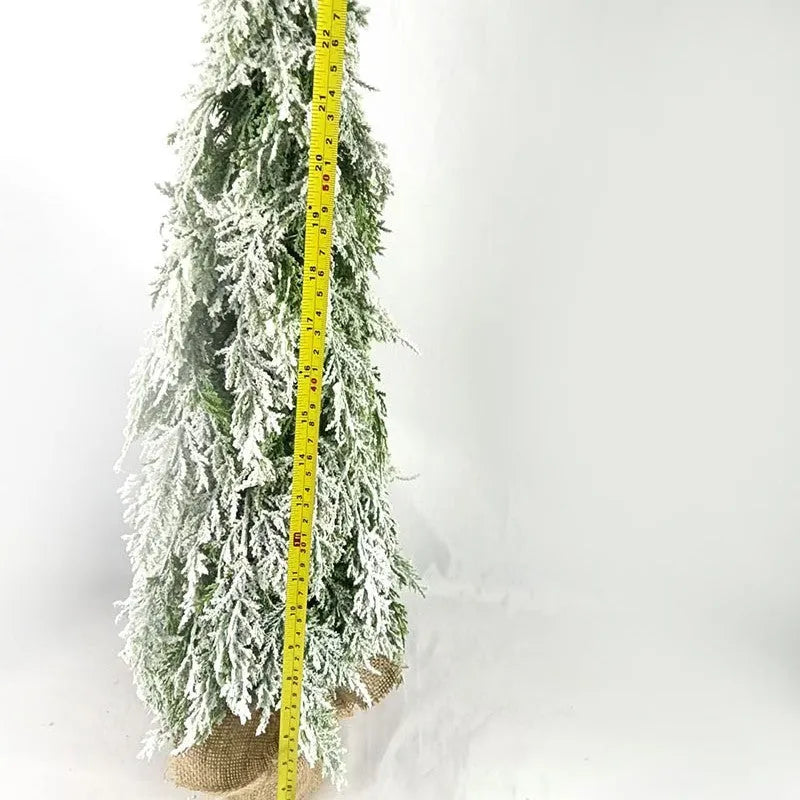 Small 24-inch white artificial Christmas tree with LED lights and snow effect on a desktop