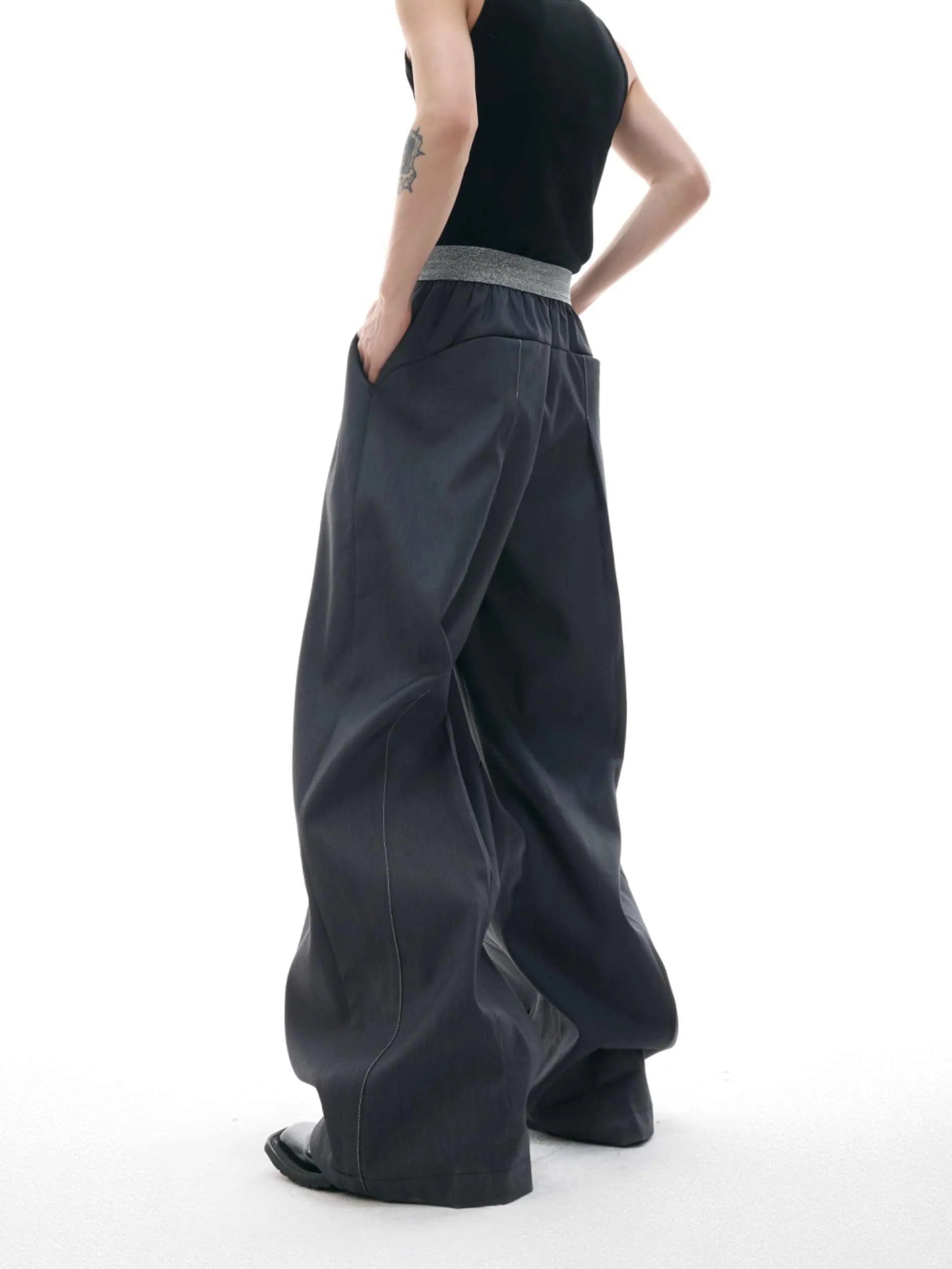 Drooping straight suit pants in black or grey with a high waist and button-open line detail.