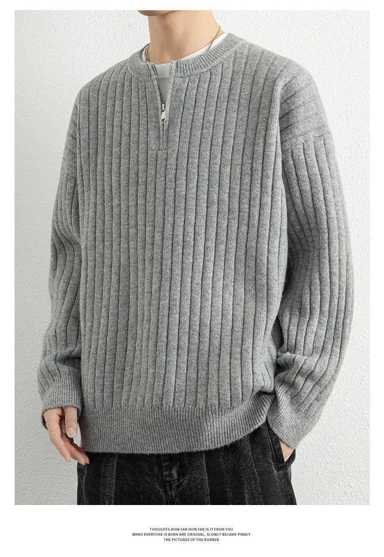 Men's loose grey half zip sweater with textured knit and long sleeves on a hanger.