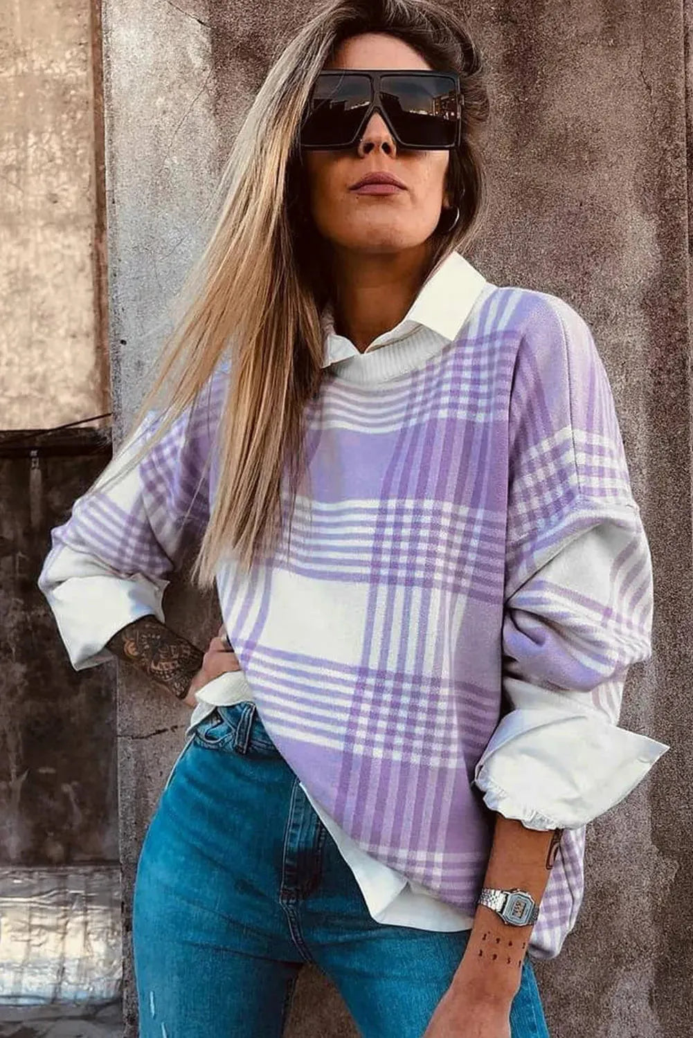 Lilac plaid print loose-fitting long sleeve sweater with ribbed trim on a hanger.