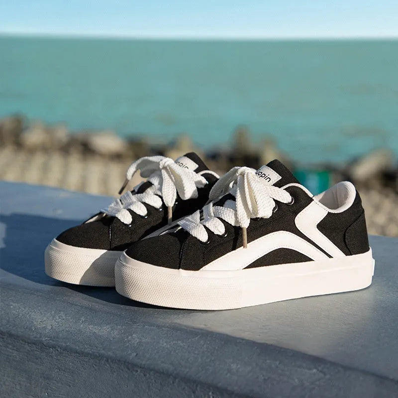 Minority women's low top board shoes in black and white colourway, synthetic leather upper, round toe.