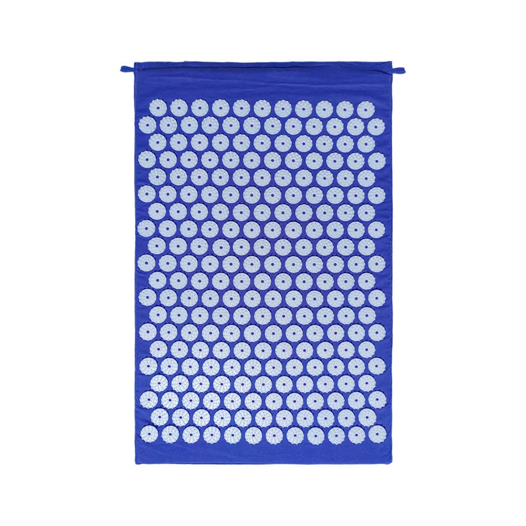 Black and blue acupuncture massage mat with cushion and headrest on floor