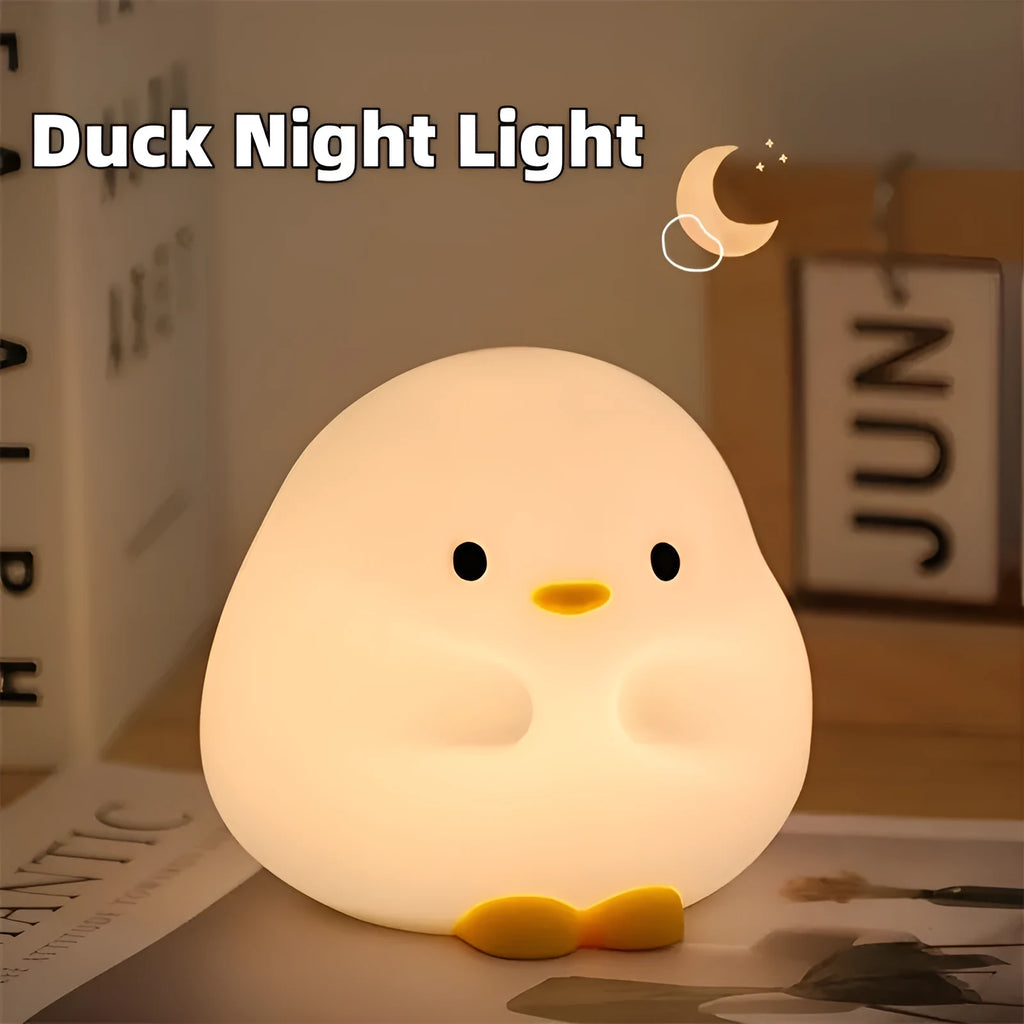 Cute duck-shaped silicone LED night lamp with touch sensor and warm glow on a bedside table