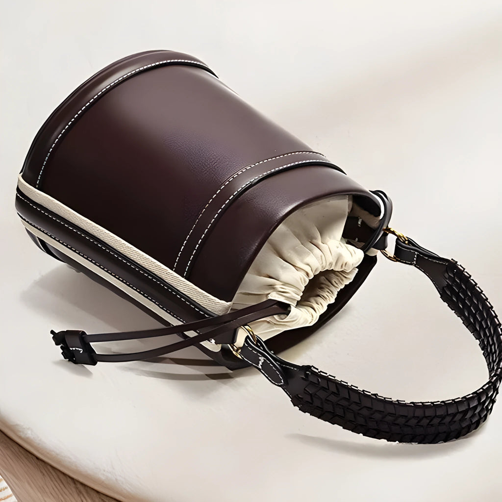 Brown PU leather bucket bag with woven texture, dual handles, and contrast stitching on a neutral background