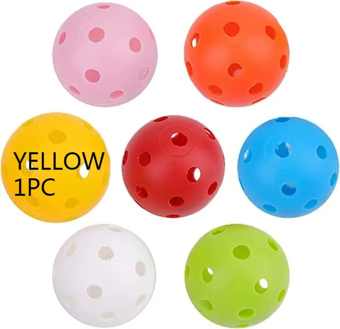 Six brightly coloured 42mm golf practice balls with a hole-patterned surface, laid out on a green net pocket.