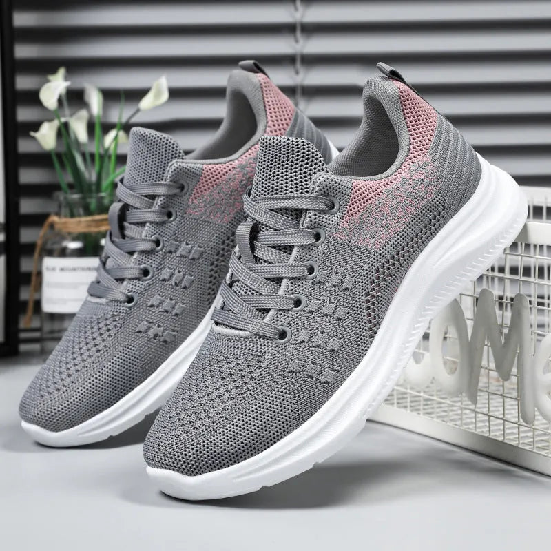 Women's black mesh sneakers with round toe and lace-up front, showing breathable construction and soft PVC sole
