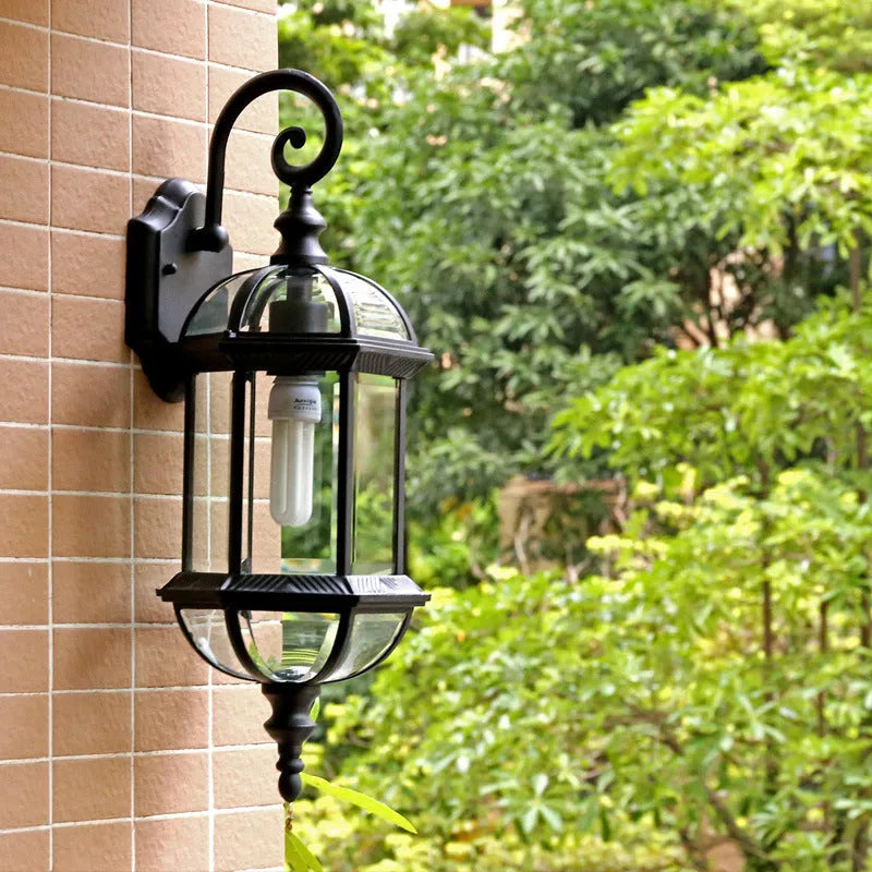 Gold aluminium outdoor wall lamp with three-layer design mounted on a brick wall.