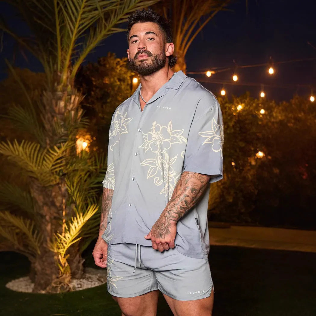 Man's loose-fitting printed short sleeve top in a light colour, showing cardigan style and floral pattern detail.