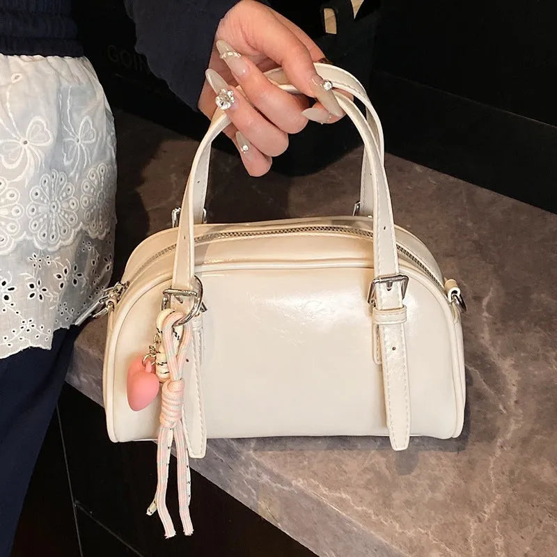 Soft PU women's shoulder bag in shell shape with sandwich pocket, shown in black with pendant strap.