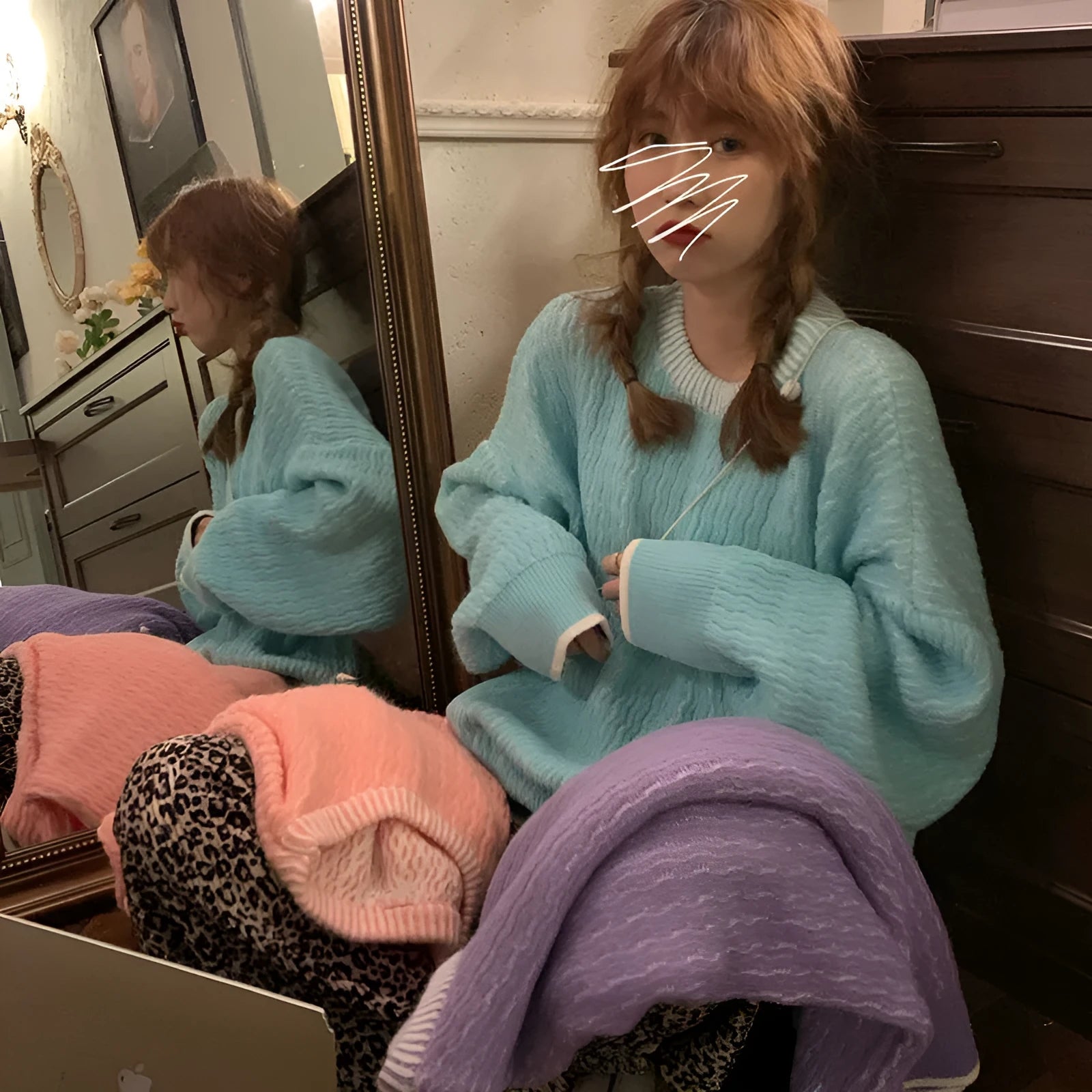 A lake blue women's loose-fit pullover sweater with long sleeves on a hanger.