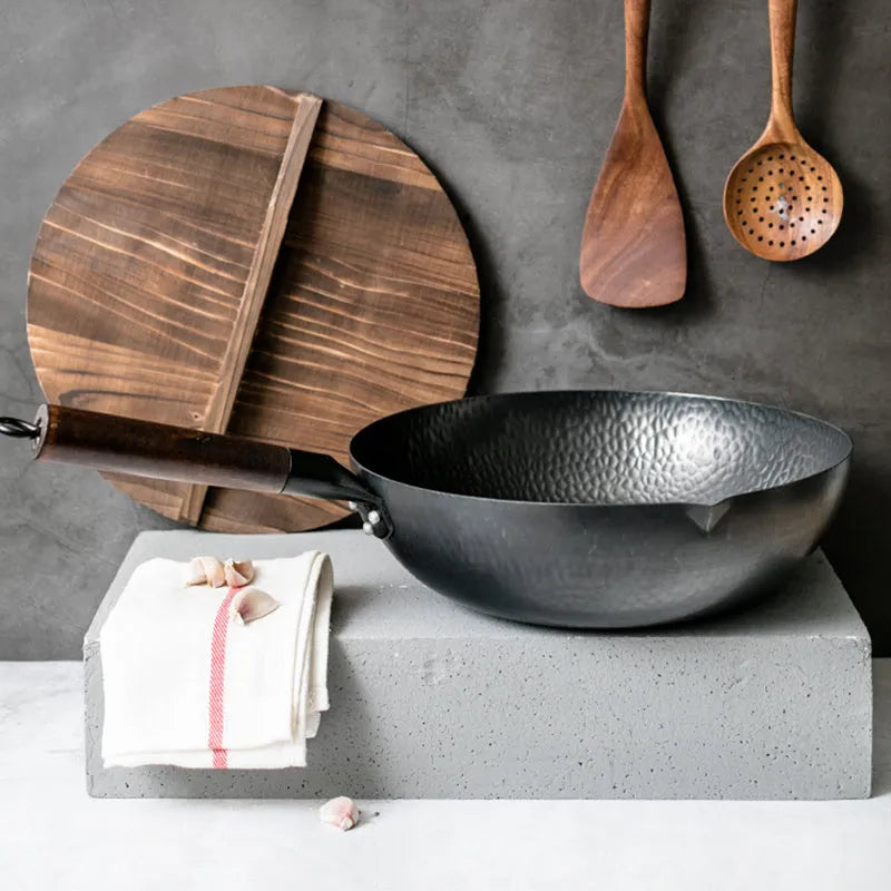 Traditional black iron wok with wooden handle, 40cm diameter, showing induction-compatible flat base