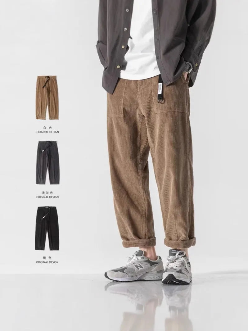 Man wearing loose tapered straight-leg trousers in a dark grey colour with wide legs.