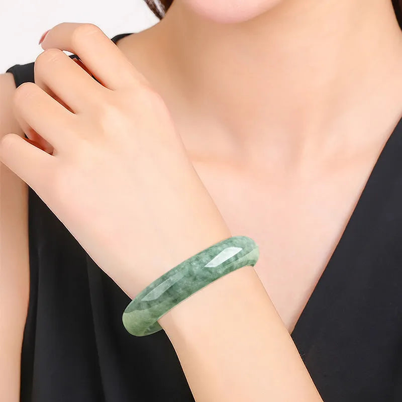 Natural emerald bean green women's bracelet on a gift box, showing simple design and deep pea green stone colour.