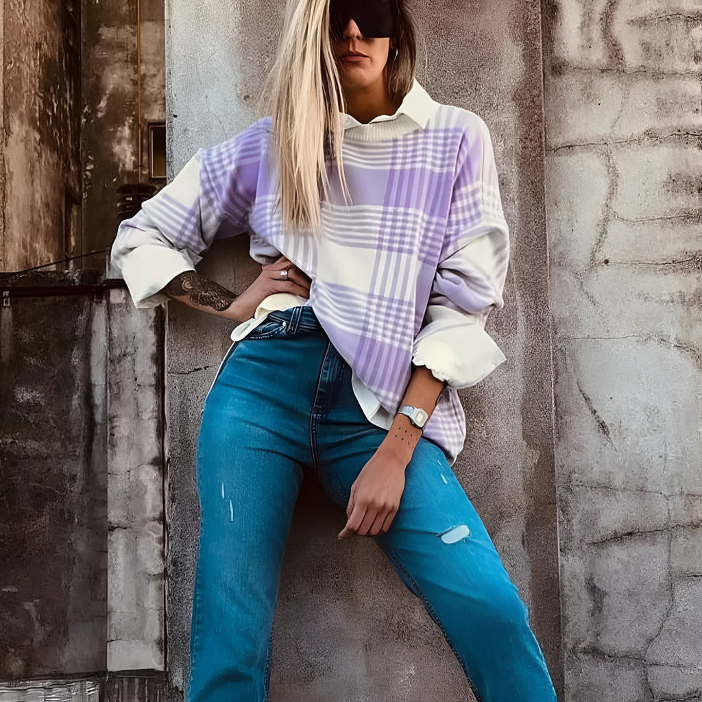 Lilac plaid print loose-fitting long sleeve sweater with ribbed trim on a hanger.