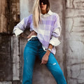 Lilac plaid print loose-fitting long sleeve sweater with ribbed trim on a hanger.