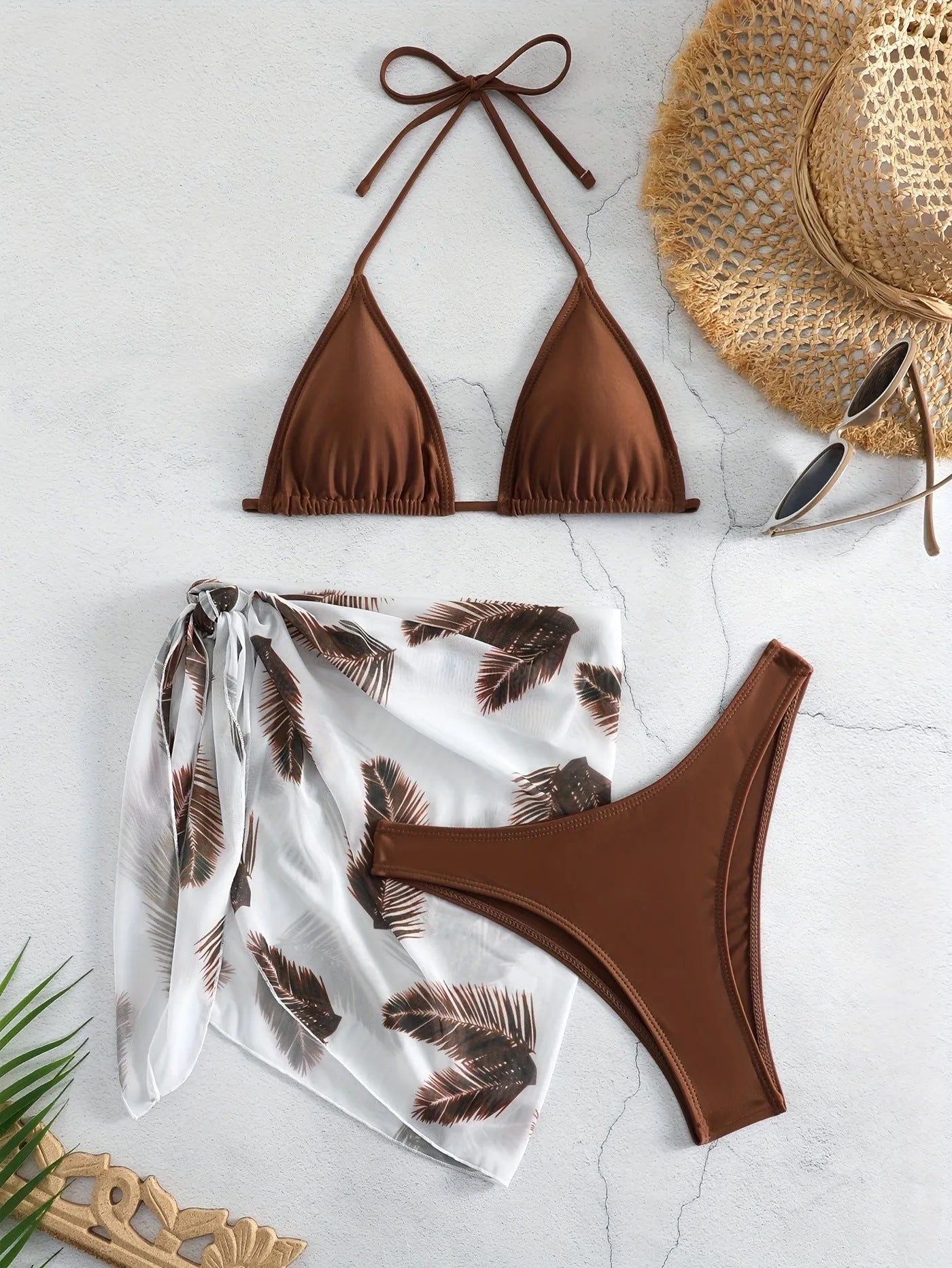 Women's orange polyester bikini set with a matching printed gauze skirt laid flat.