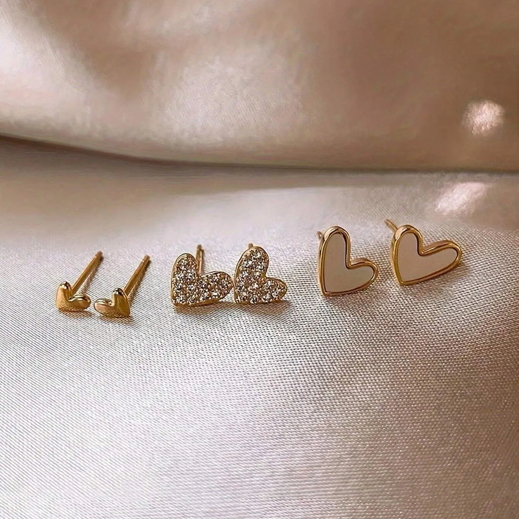 Three pairs of heart-shaped alloy earrings in gold, black, pink, and black-white colours