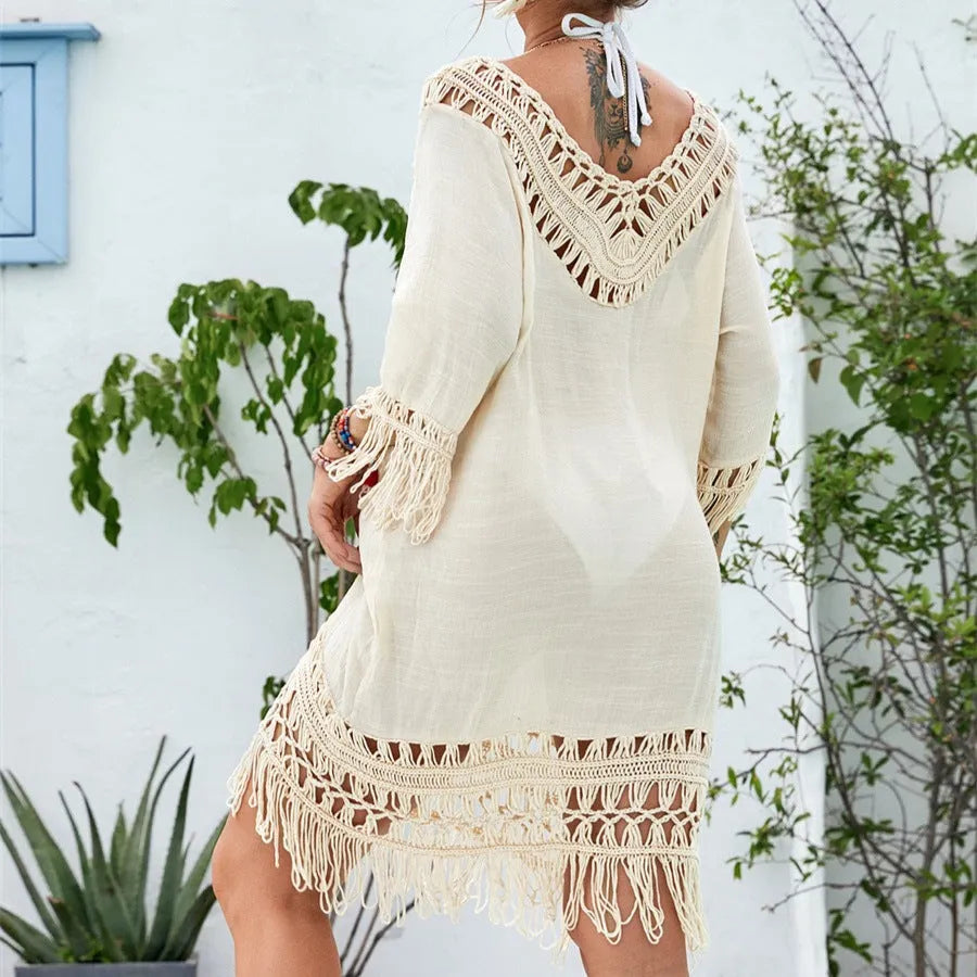 Apricot crocheted patchwork dress on a hanger showing regular sleeves and midi length.
