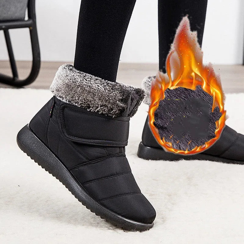 Women's winter snow boots with plush lining, suede upper, velcro strap, flat heel, and anti-skid rubber sole in black.