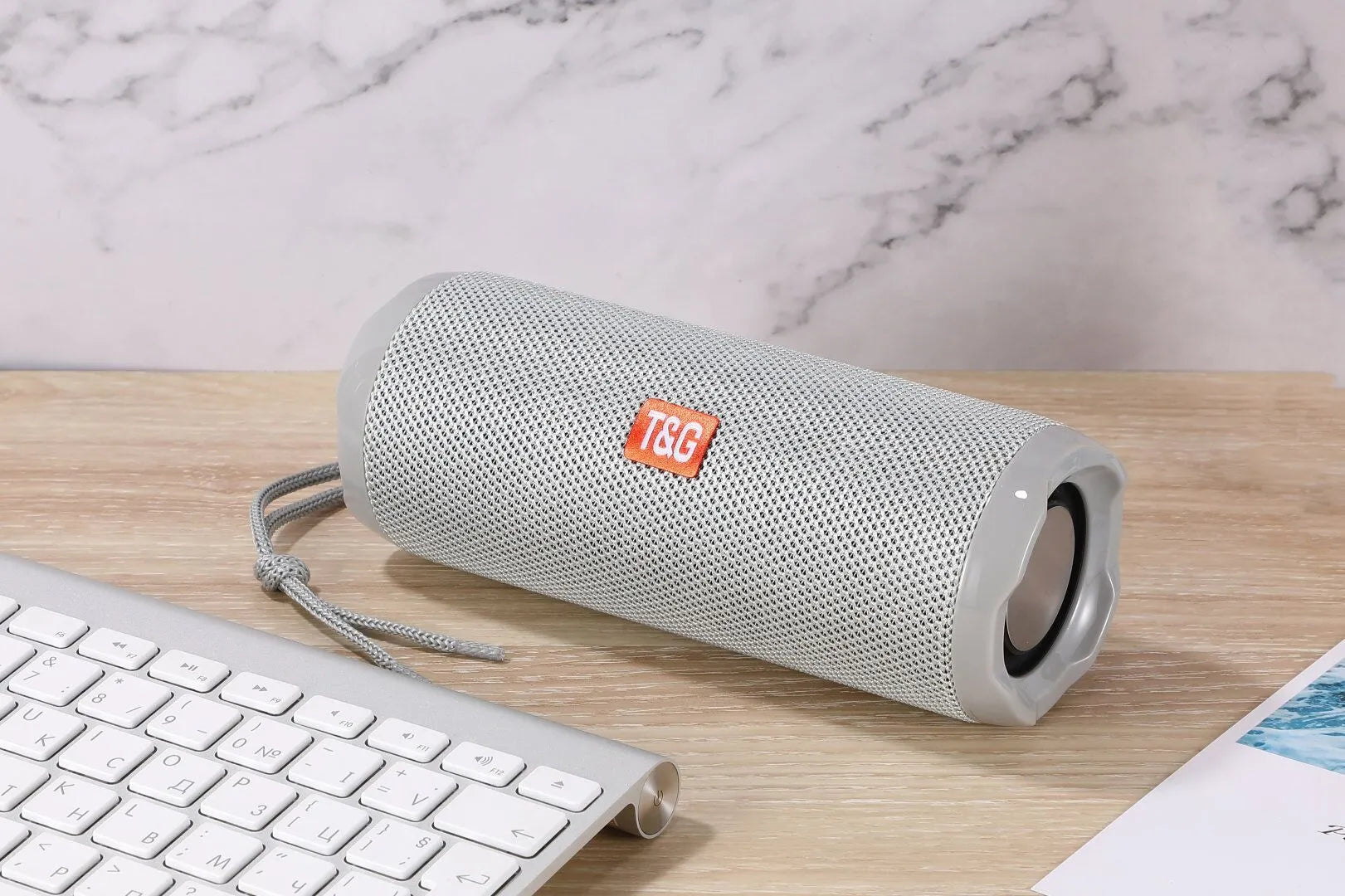 Fabric-covered portable Bluetooth speaker with a visible card slot in one of six colour options.