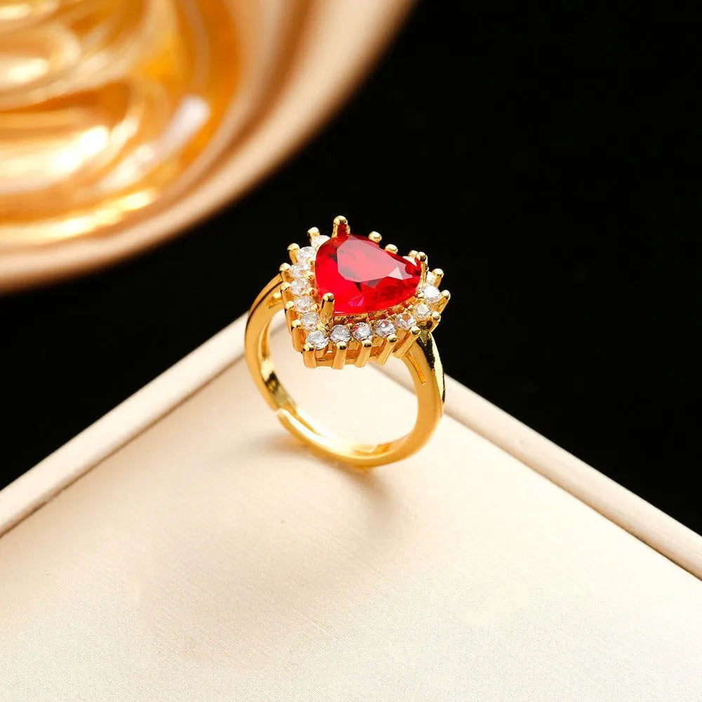 Gold-red titanium steel heart and flower necklace, earrings, and ring set on display