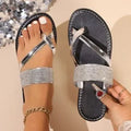 Women's beach sandals with rhinestone toe strap and flat rubber soles in black, gold, and silver colours