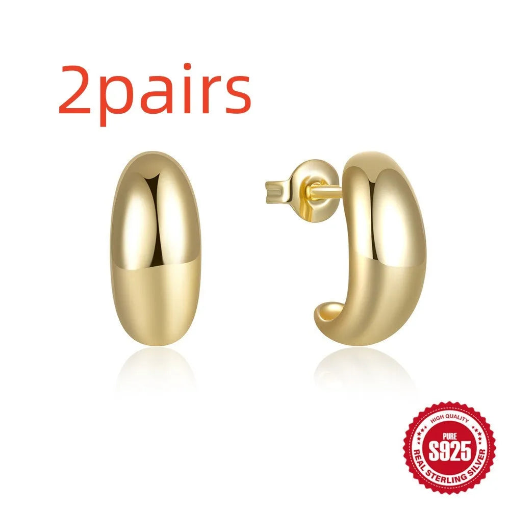 C-shaped sterling silver stud earrings with glossy electroplated finish in gold colour