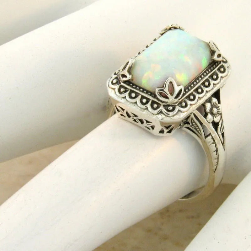 Silver alloy geometric ring with inlaid opal stone on a white background