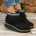 Women's suede wedge ankle boots with a thick platform sole, side zip, and tassel detail in dark brown.