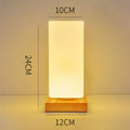 Nordic style solid wood USB table lamp in a cube shape with touch dimming on a wooden desk.
