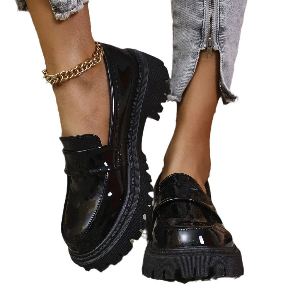 Women's black slip-on loafers with a chunky rubber sole and thick platform heel.