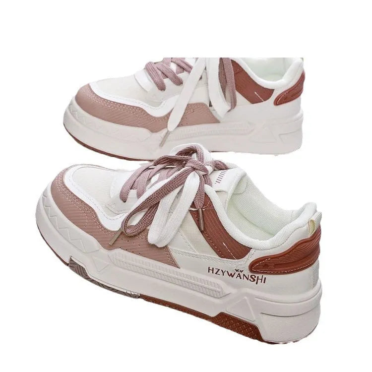 Beige children's platform trainers with cross shoulder straps and white rubber soles on a wooden floor.