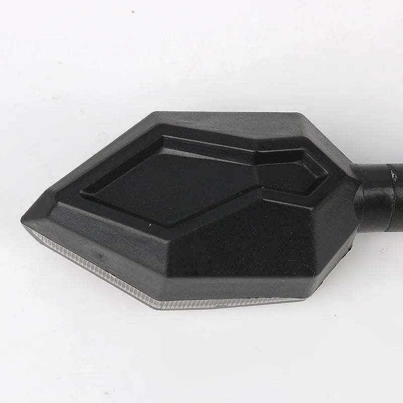 Arrow-shaped LED motorcycle turn signal light unit for 12V vehicles, shown in available colour options.