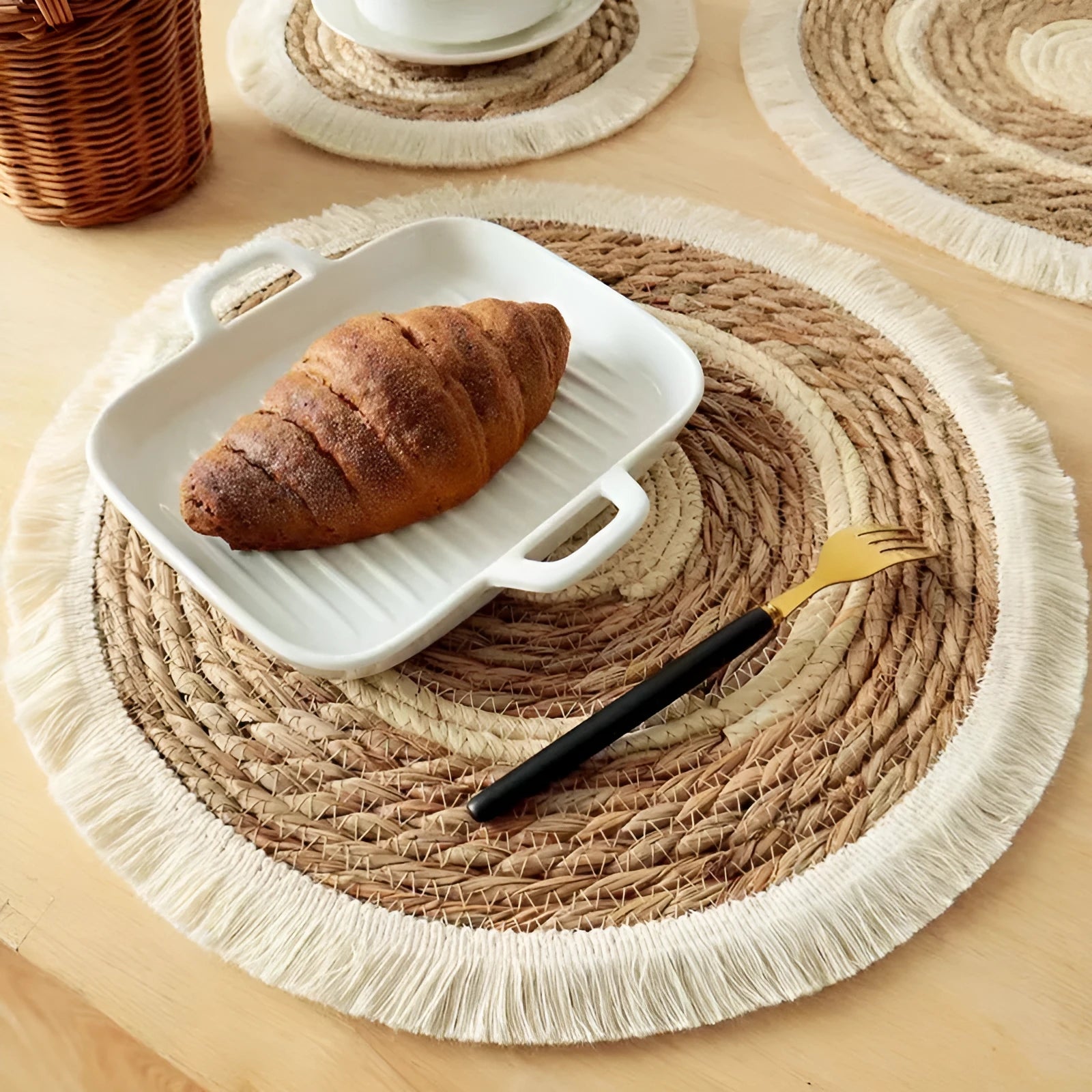 Round Japanese straw placemat with tassel edge on dining table