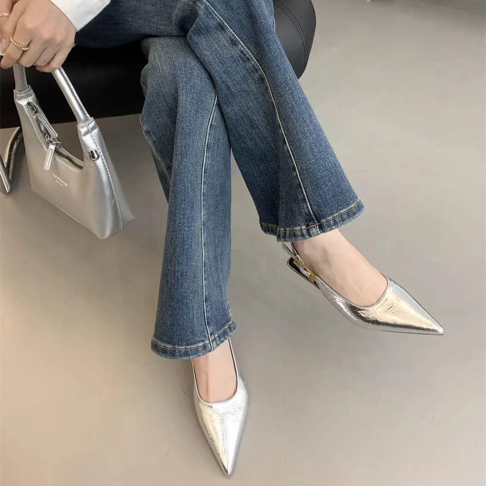 Black leather pointed toe women's shoes with a thin low heel and an ankle strap.