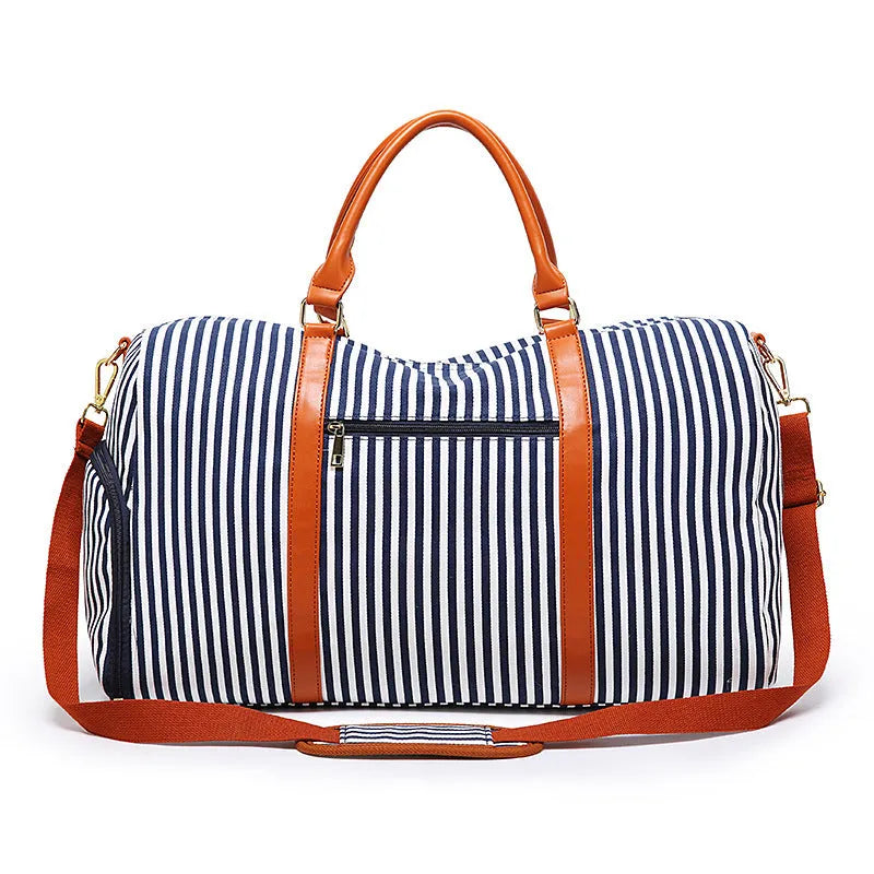 Large striped canvas travel duffel bag with contrast colour and leather detailing, horizontal square shape and zip top.