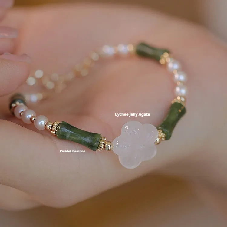 Close-up of a handcrafted Chinese antique style bracelet with bamboo joint design, featuring Hetian jade and 4mm shell pearls with copper details.