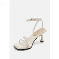 Women's silver rhinestone sandals with square toe and ankle strap buckle on a rubber sole.