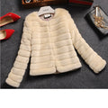 Woman wearing a short white faux fur top with regular sleeves, styled with jeans.